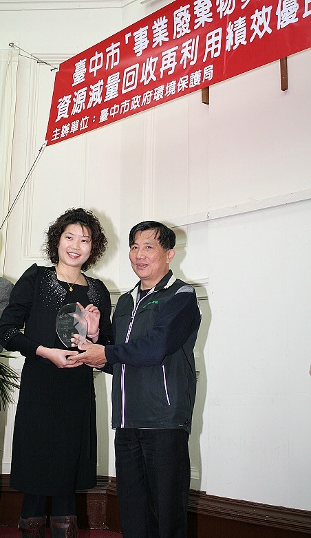 图说：台中市政府主秘蔡宗贤(右)颁发绩效优良奖给亚洲大学环安室王美青小姐(左)。